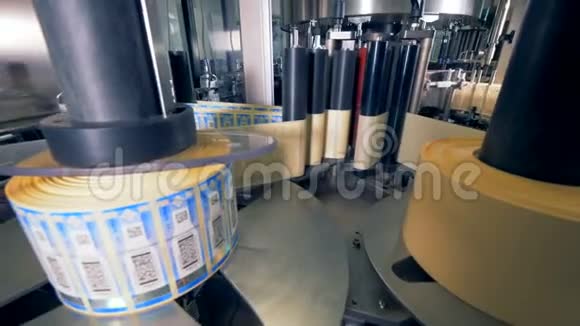 瓶子的标签卷特殊的机器旋转在工厂的瓶子上贴上标签视频的预览图