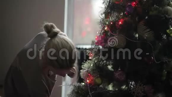 小女孩在窗边装饰圣诞树视频的预览图