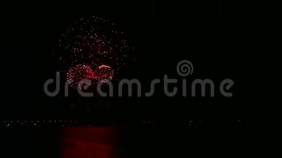 江面夜空中闪烁着灿烂的烟花火花映在水中时间跨度视频的预览图