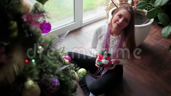 漂亮女孩在镜头上展示一个圣诞玩具视频的预览图