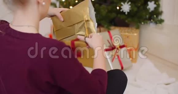 妇女在家用壁炉包圣诞礼物视频的预览图
