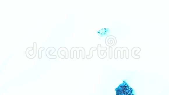 五颜六色干燥蓝色墨水在白色液体彩虹色背景明亮的蓝色粉末在液体物质中移动视频的预览图