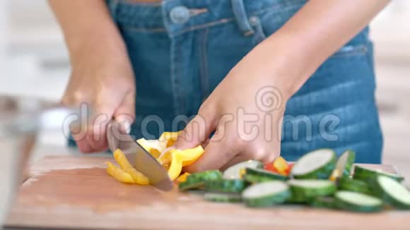 特写女性手切新鲜的夏季蔬菜用刀烹饪健康素食沙拉视频的预览图