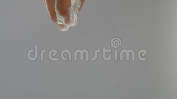 贝克双手缓慢地把面粉倒在灰色背景上视频的预览图