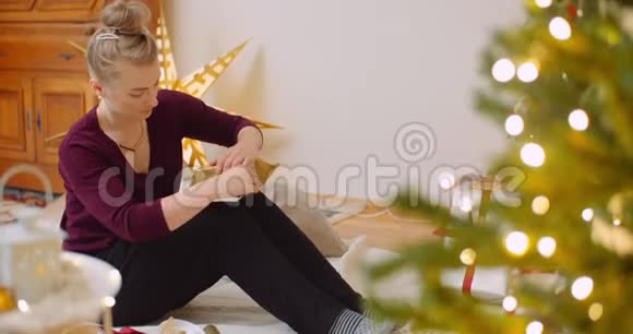 妇女在家中用壁炉包装圣诞礼物视频的预览图
