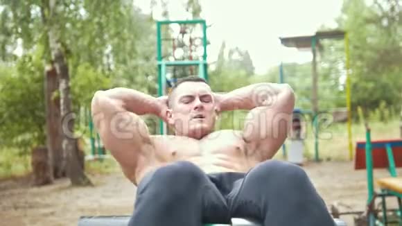 肌肉男在户外运动公园锻炼腹肌视频的预览图