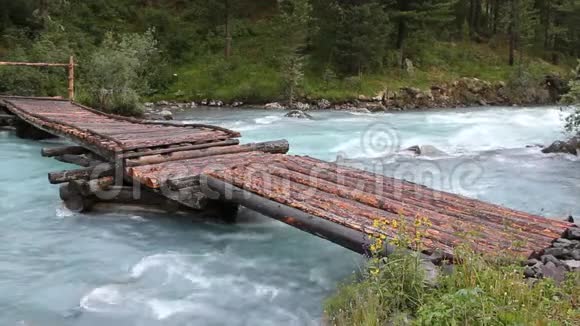 俄罗斯阿尔泰山库什拉河山河上的人行木桥视频的预览图