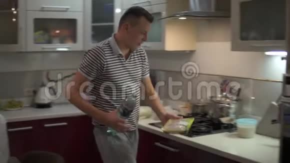一个男人在厨房里整理食物货架上的铅视频的预览图