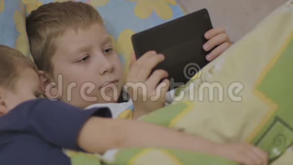 儿童在床上使用在线设备视频的预览图