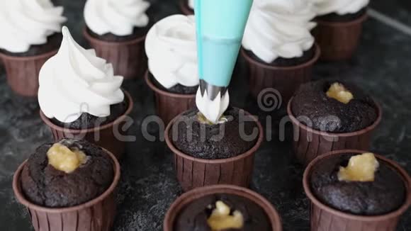 糖果师用鲜奶油装饰巧克力松饼视频的预览图