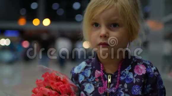 在机场休息室拿着一束玫瑰的小女孩视频的预览图