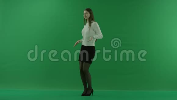 女孩站在一个半转弯看着左边在绿色的屏幕上移动视频的预览图