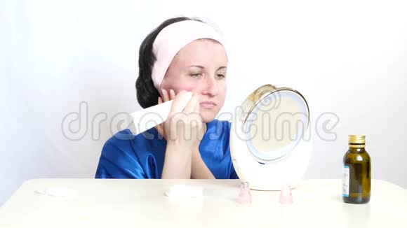 一个女孩用一个设备在白色背景上对面部皮肤进行微磨损美的概念视频的预览图