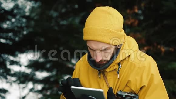 坐在青山旁边的绿树下一个年轻人正在寻找一条新路他用的是平板电脑视频的预览图