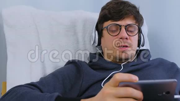 人类在智能手机上用耳机听音乐用卡拉OK唱一首歌放松的时间视频的预览图