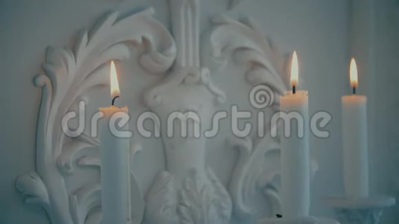 在墙的背景上点燃白色的蜡烛视频的预览图