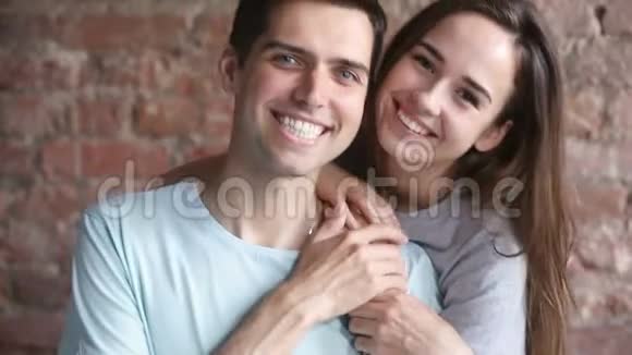 年轻多情的情侣拥抱牵着手微笑着拍照视频的预览图