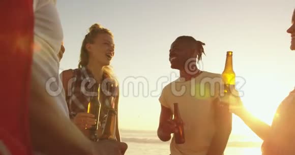 日落时分在海滩上喝酒的年轻成年朋友视频的预览图