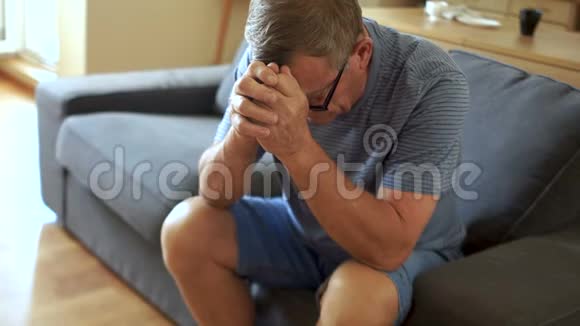 一位抑郁症老人坐在沙发上他低着头看着养老金领取者的问题视频的预览图