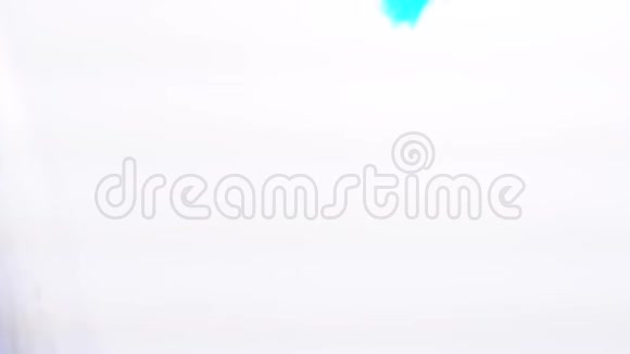 蓝色凝胶滴落在白色背景的水中特写视频的预览图