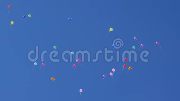 美丽的彩色气球在天空中飞翔红蓝黄橙粉许多五颜六色的气球在空中飞舞视频的预览图