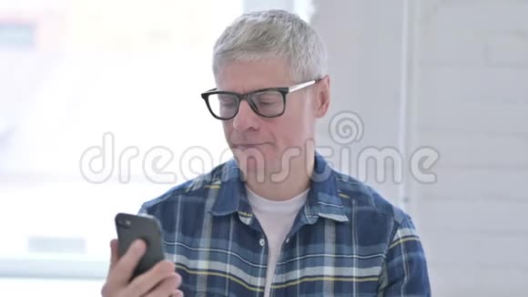 休闲中年男人在智能手机上说话的肖像视频的预览图