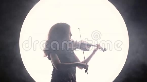 女音乐家的剪影小提琴手在一个白色圆圈的衬托下用烟弹小提琴视频的预览图