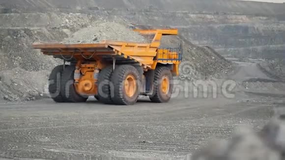 在装满矿石的采石场道路上行驶的自卸卡车的特写镜头视频的预览图