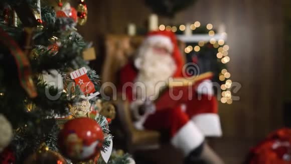 模糊的圣诞老人手里拿着旧的红绸相册放着玩具和灯视频的预览图