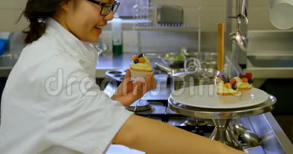 女厨师在4k餐厅厨房装饰松饼视频的预览图