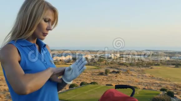 女人在打高尔夫球前戴上手套视频的预览图