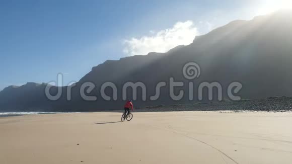 年轻人骑自行车在加那利群岛的沙滩上兰萨罗特大西洋视频的预览图