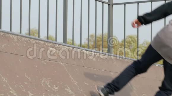 溜冰者在斜坡边缘的滑板尾巴上做花样特写慢动作视频的预览图
