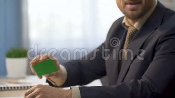 商人坐在办公室的办公桌前展示着绿色的卡片银行服务视频的预览图