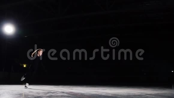 一名职业花样滑冰运动员穿着黑色西装在空中跳跃以黑色背景表演滑冰慢视频的预览图