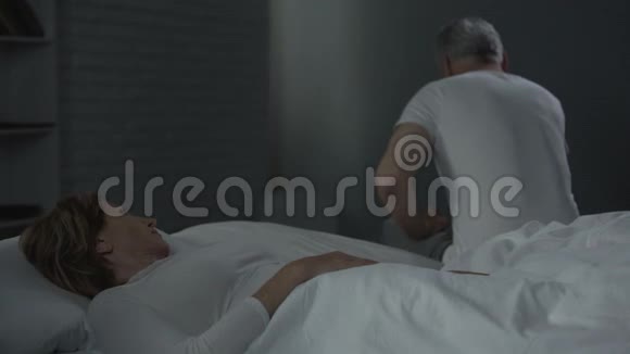 躺在床上的女人看着床边的男人沉重地叹息着冲突视频的预览图