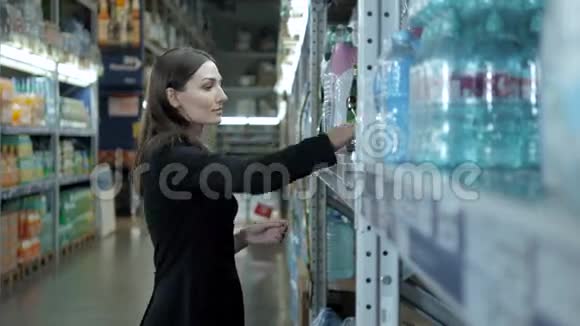 微笑的女人在超市的杂货店买了一瓶水女商人在购物视频的预览图