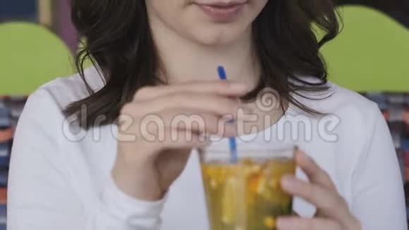 在咖啡馆里近距离观看女孩的激动和喝柠檬水视频的预览图