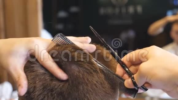 理发师的男性手在沙龙中用梳子和剪刀梳理和剪发理发师的手臂视频的预览图