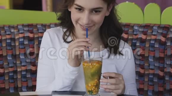 在咖啡馆里近距离观看女孩的激动和喝柠檬水视频的预览图