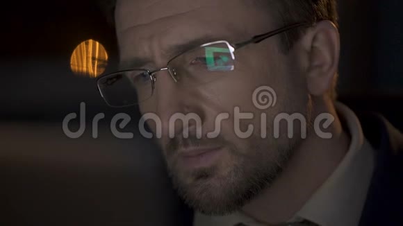 男性坐在笔记本电脑旁查看信息眼镜显示笔记本电脑屏幕视频的预览图