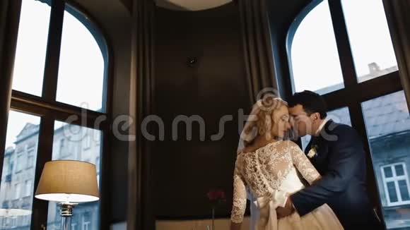 快乐时尚的新婚夫妇在现代餐厅里轻轻地拥抱和亲吻视频的预览图