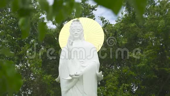 佛寺中的佛像妻子背景是绿色的植物和树木古代佛教宗教雕塑视频的预览图
