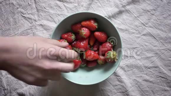 不同的手从碗里拿草莓视频的预览图