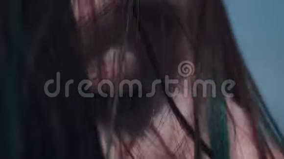 一个年轻的黑发女人在刮风的天气里的脸一副若有所思的样子看向远处慢动作视频的预览图