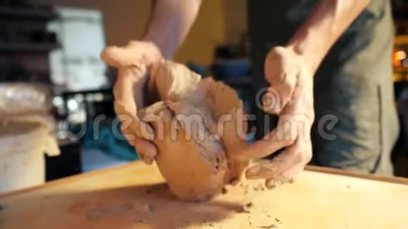 陶器和陶瓷雕塑家在桌子上捣鼓和捏泥视频的预览图