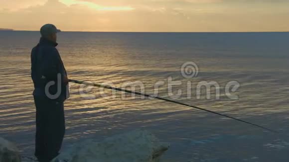 老人用鱼竿从岩石海岸钓鱼活动休息神奇时刻视频的预览图