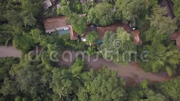 从无人驾驶飞机俯瞰全景丛林中的棕色河流一岸有温泉酒店视频的预览图