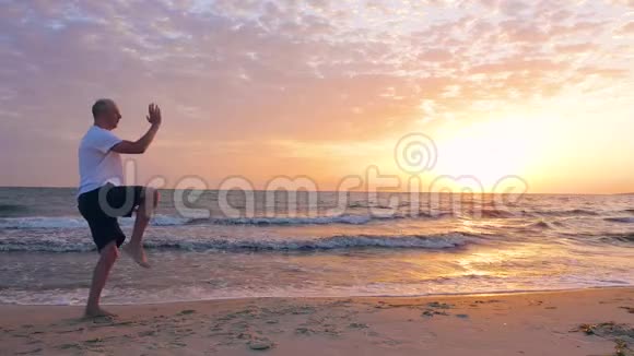 男子训练太极拳晚上在海边日落视频的预览图