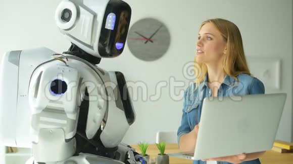 机器人和女人看着笔记本电脑聊天视频的预览图